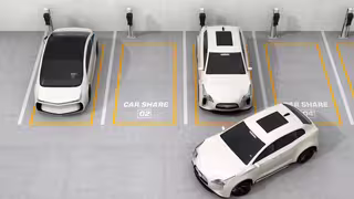 Mehrere Carsharing-Fahrzeuge stehen auf markierten Parkplätzen mit Ladestationen.